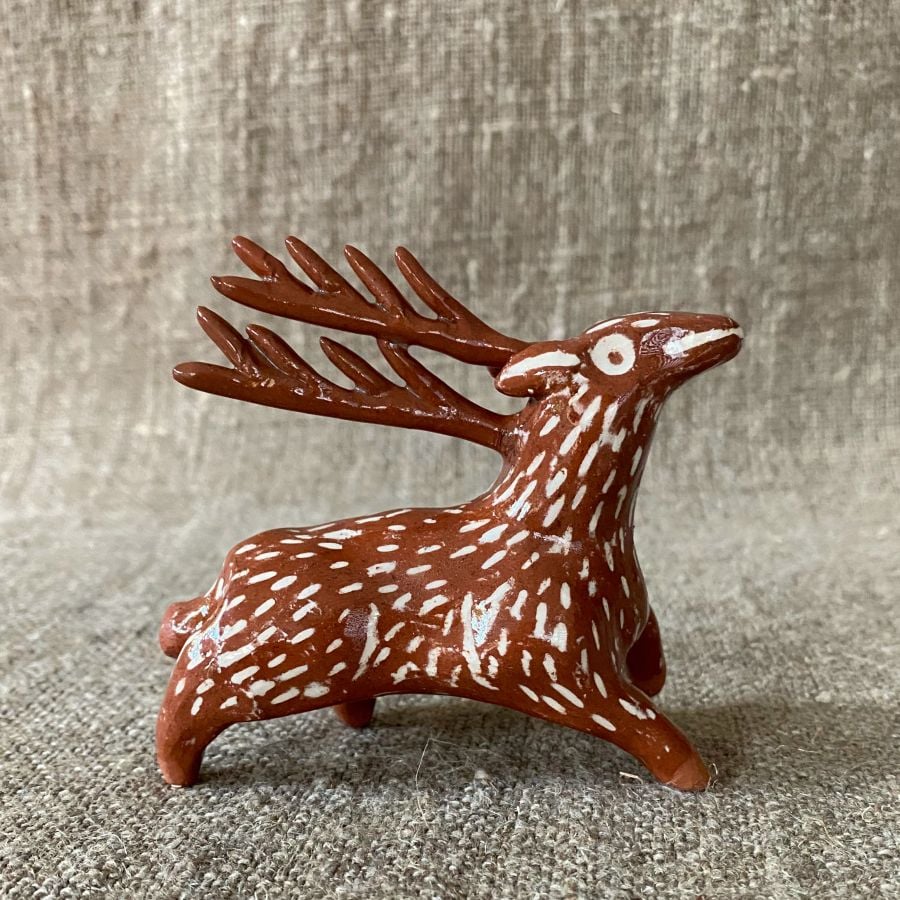 Emma Carlow pottery whistle in the shape of a reindeer against a cloth backdrop