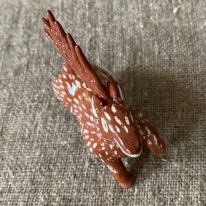 Emma Carlow pottery whistle in the shape of a reindeer against a cloth backdrop