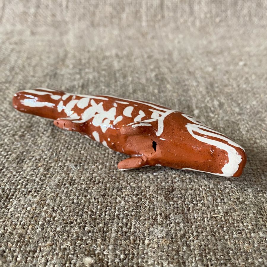 Emma Carlow pottery whistle in the shape of a FISH against a cloth backdrop