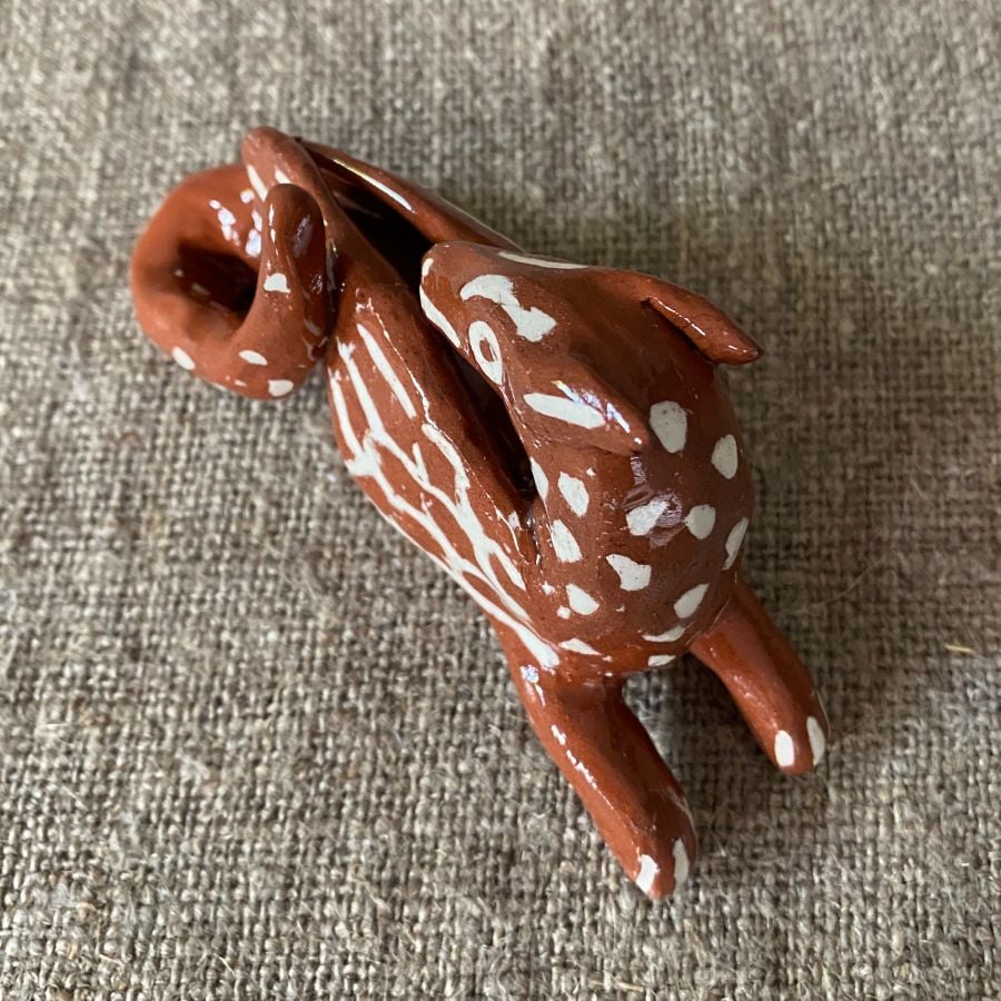 Emma Carlow Pottery whistle in shape of a dragon on a fabric background