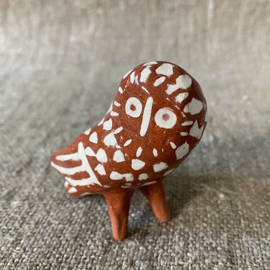 Emma Carlow Pottery whistle in shape of an owl on a fabric background