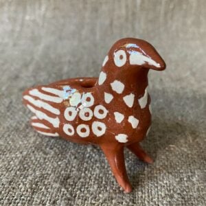 Emma Carlow Pottery whistle in shape of a Bird on a fabric background