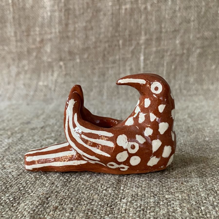 Emma Carlow pottery whistle in the shape of a bird on a cloth background