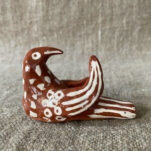 Emma Carlow pottery whistle in the shape of a bird on a cloth background