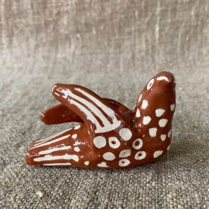Emma Carlow pottery whistle in the shape of a bird on a cloth background