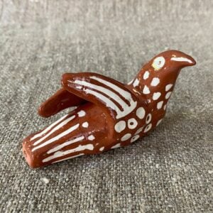 Emma Carlow pottery whistle in the shape of a bird on a cloth background