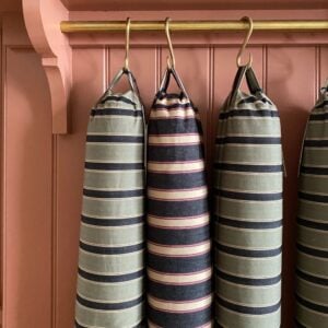 Trio of striped draught excluders hanging from hooks