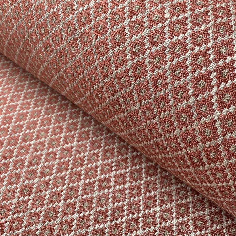 Brick red upholstery fabric with a small diamond shaped pattern in the weave