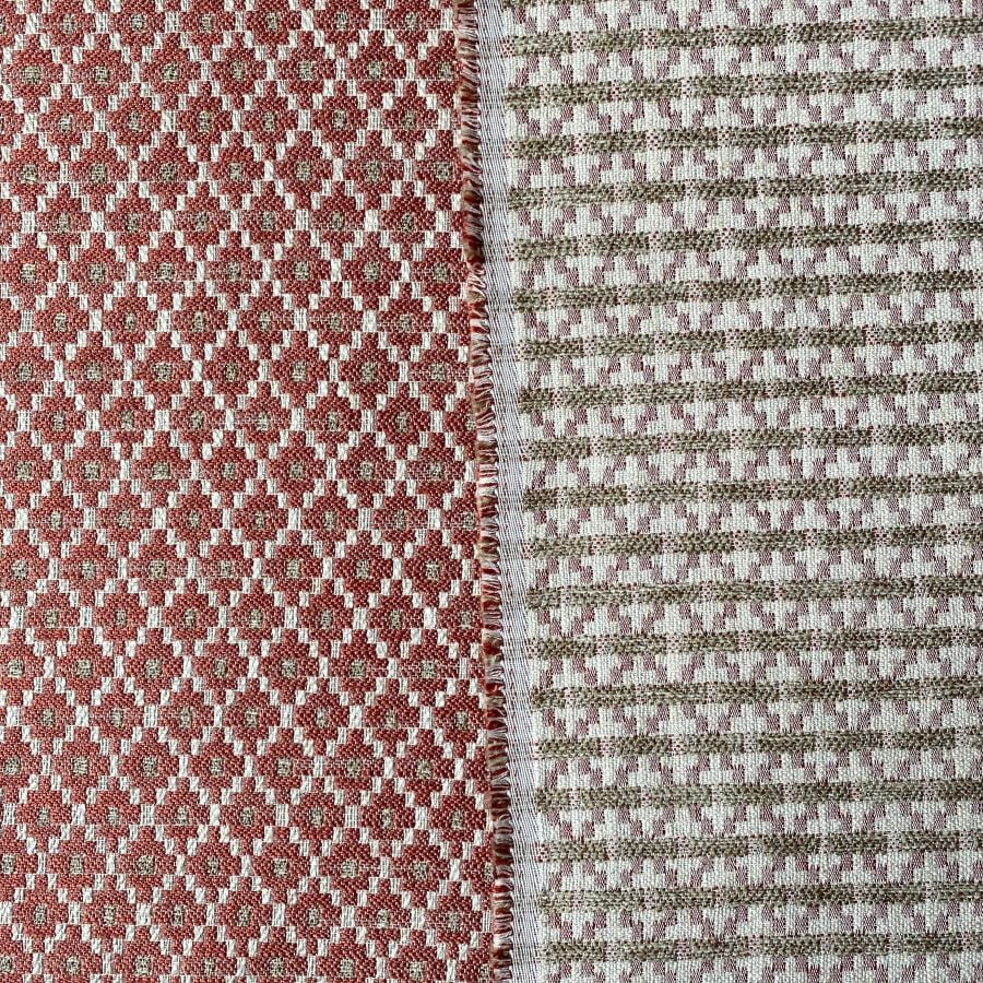 Brick red upholstery fabric with a small diamond shaped pattern in the weave