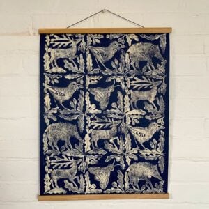 Sarah Burns Patterns beast poster hanging on a white brick wall.