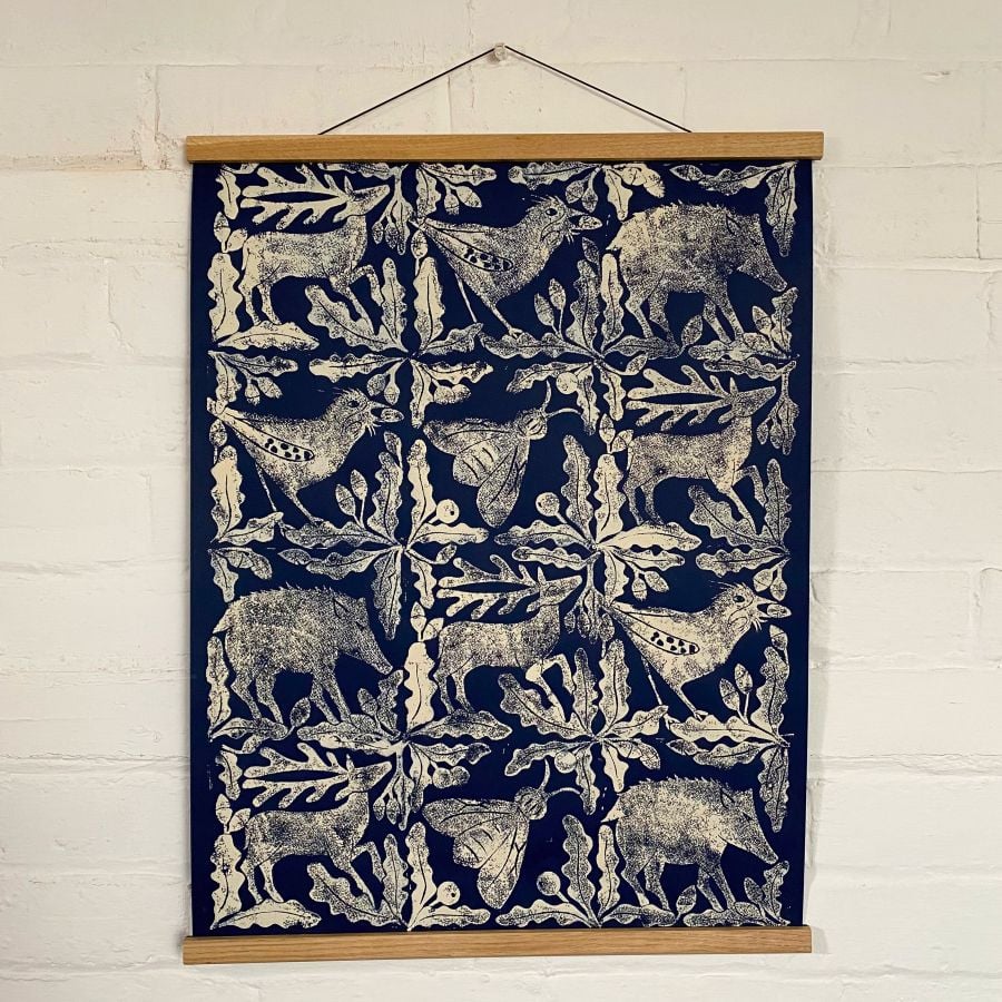 Sarah Burns Patterns beast poster hanging on a white brick wall.