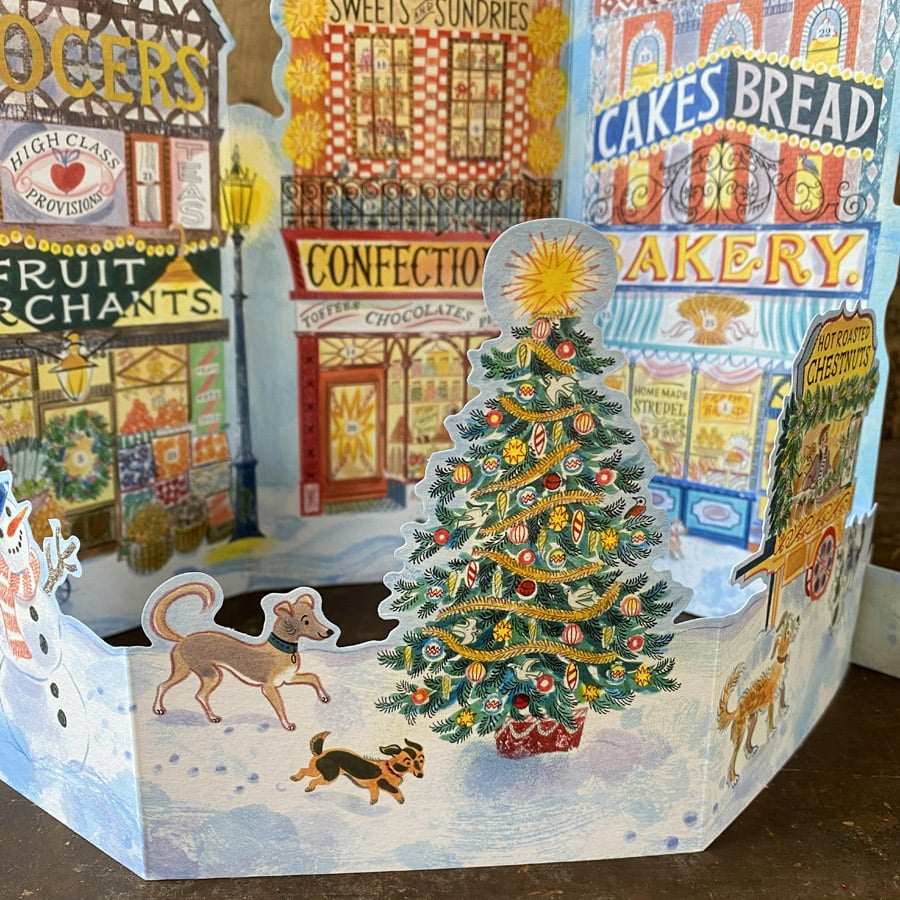 Emily Sutton's illustrated High Street advent calendar, upright against a wooden backdrop