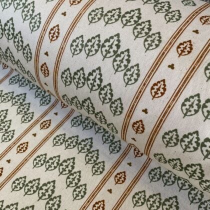 Striped pattern fabric on a slant with a repeated tree design in green & brown