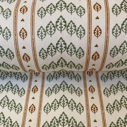 Striped pattern fabric on a slant with a repeated tree design in green & brown