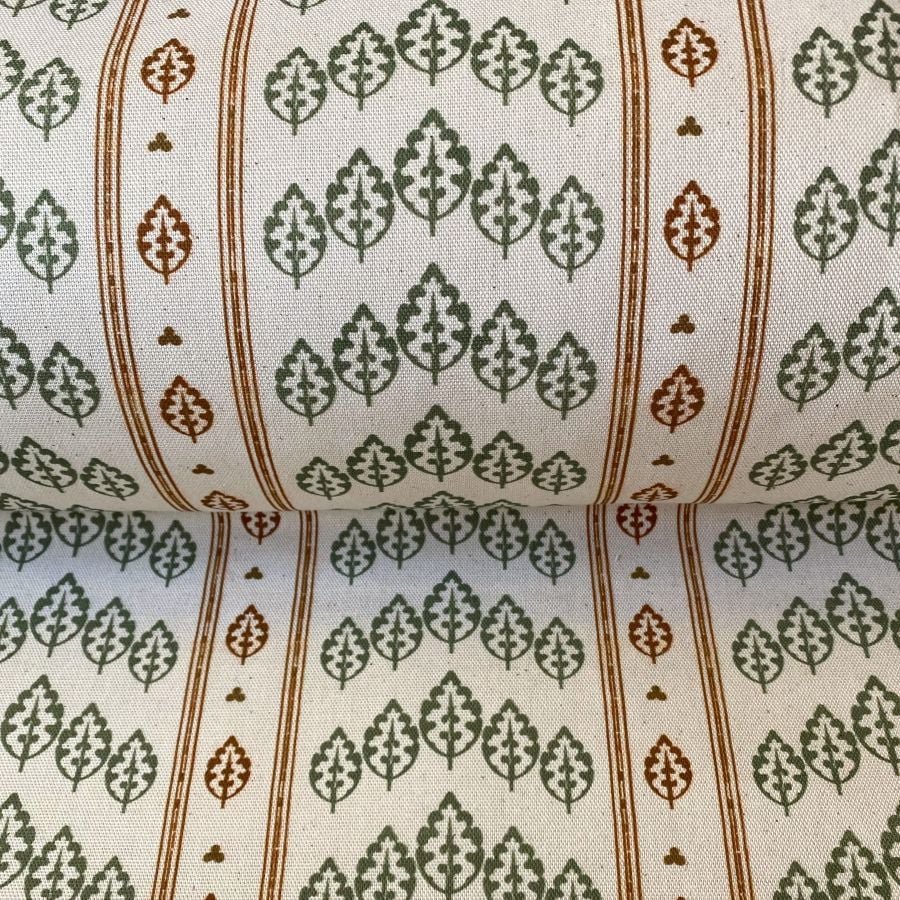Striped pattern fabric on a slant with a repeated tree design in green & brown
