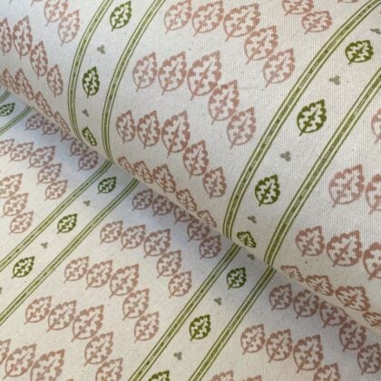 Detail of a roll of striped fabric with a tree motif, in pink, green & ivory