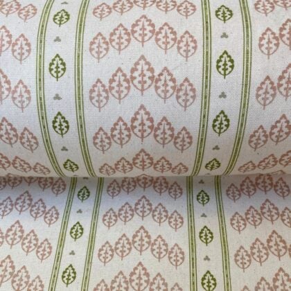 Detail of a roll of striped fabric with a tree motif, in pink, green & ivory