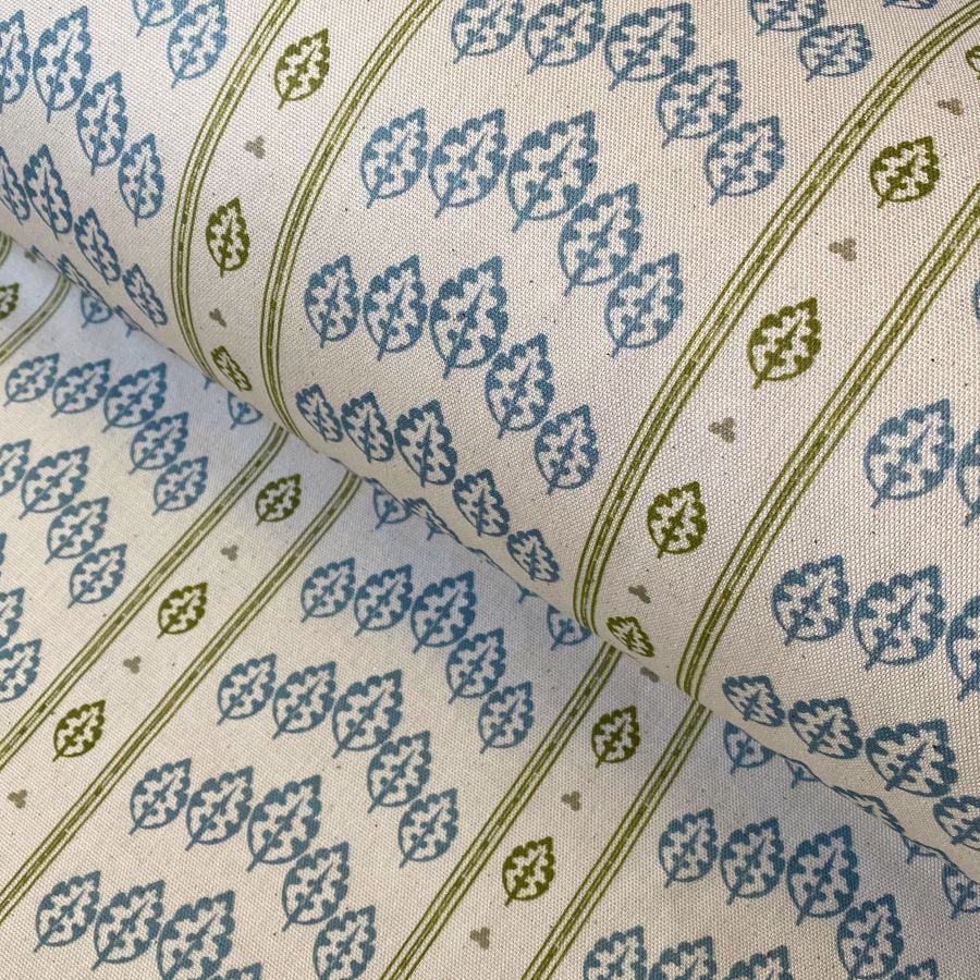 Striped pattern fabric on a slant with a repeated tree design in blue and olive green