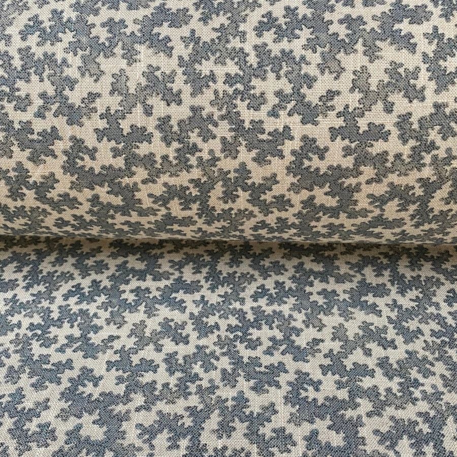 A small scale patterned fabric with a blue sinuous print