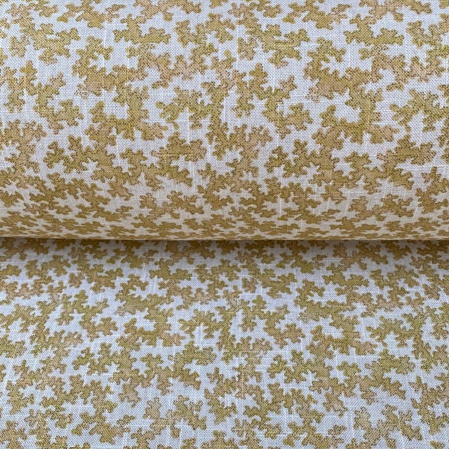 Slanted roll of fabric featuring a small scale coral design in mustard yellow