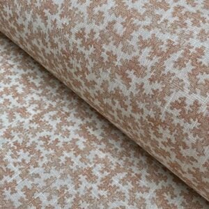 Slanted roll of fabric featuring a small scale coral design in pink