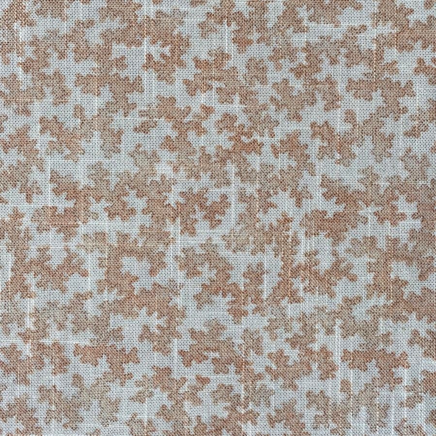 Slanted roll of fabric featuring a small scale coral design in pink