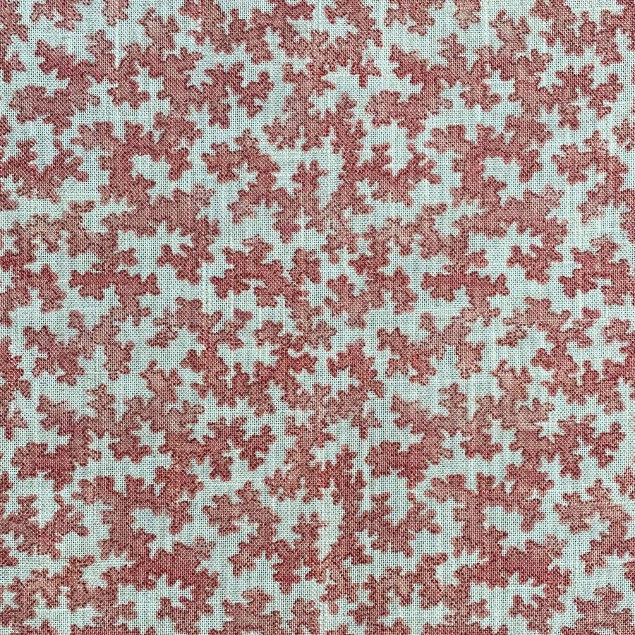 Slanted roll of fabric featuring a small scale coral design in pinkish red