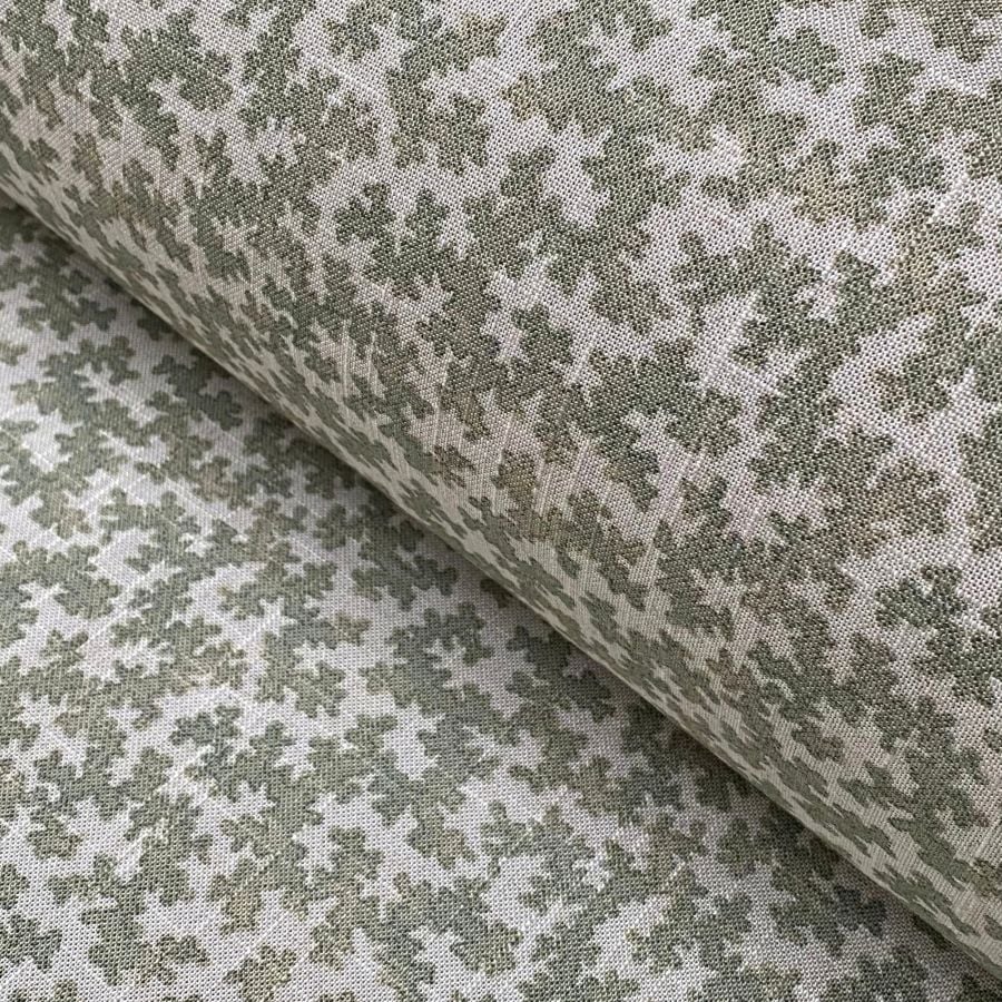 Fabric roll on a slant featuring a small scale print in green