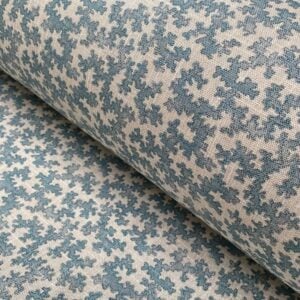Slanted roll of fabric featuring a small scale coral design in light blue