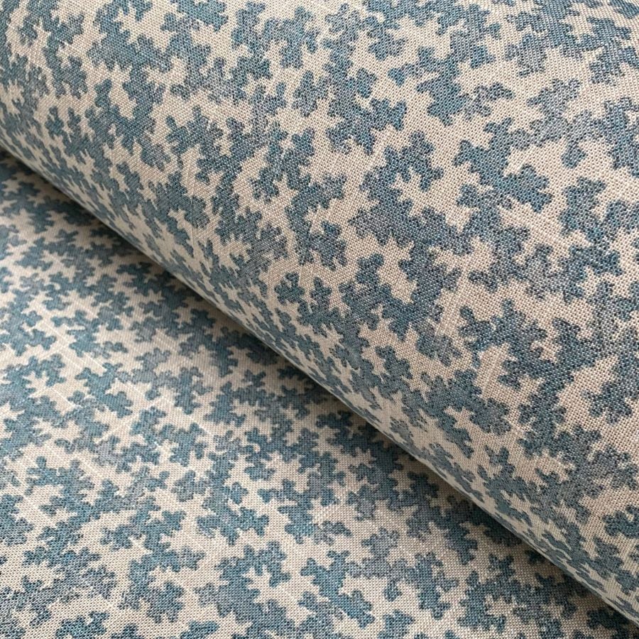 Slanted roll of fabric featuring a small scale coral design in light blue