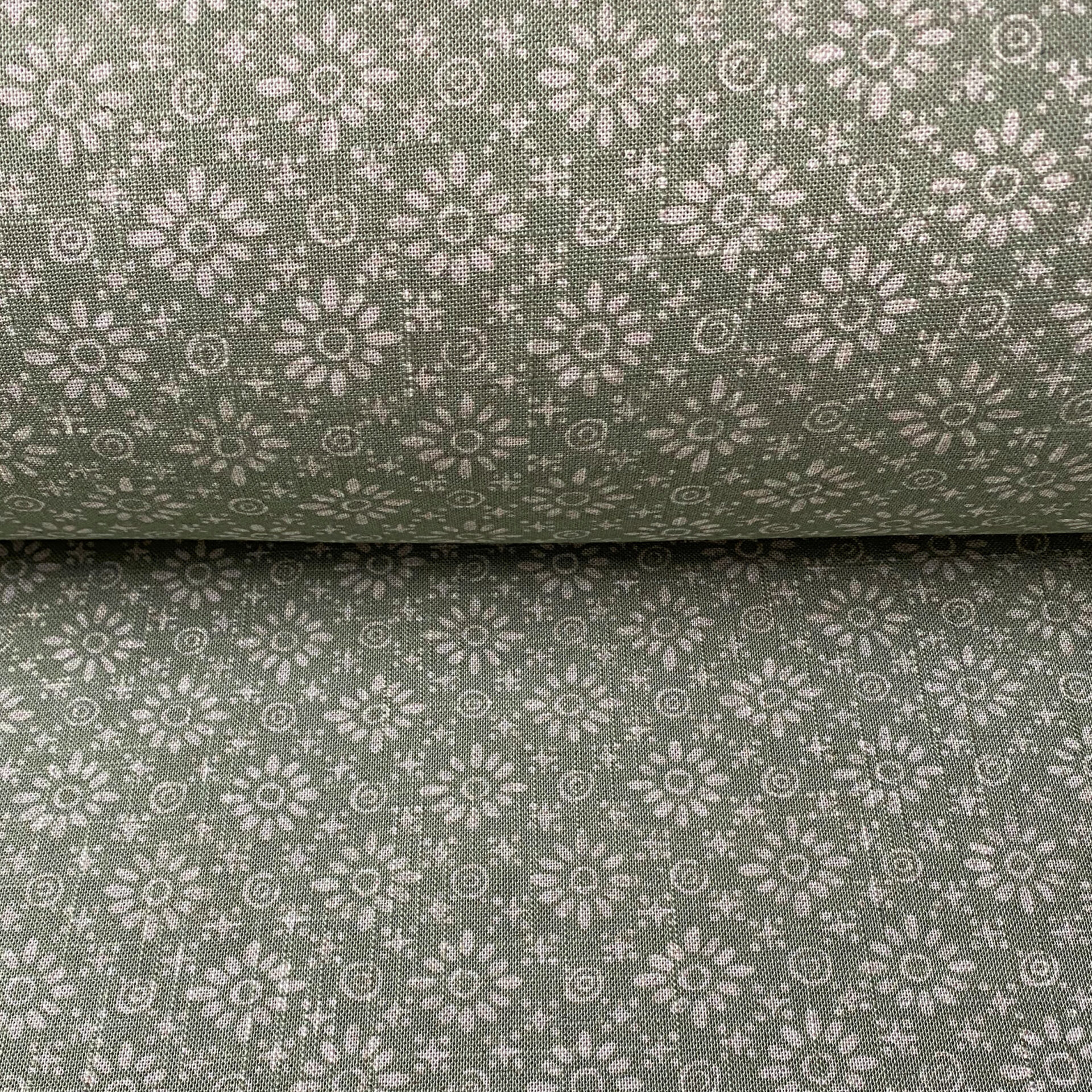 Roll of fabric with a sage green floral design
