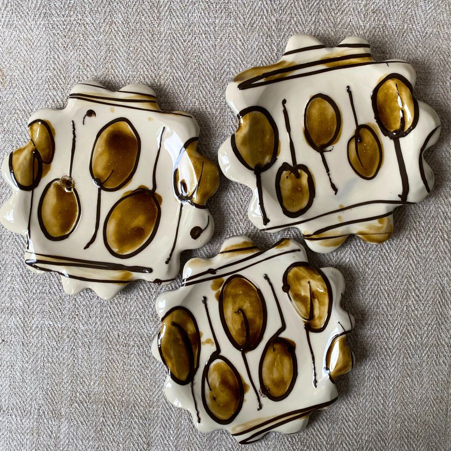 White glazed plates with scalloped edge againsta a pale fabric background