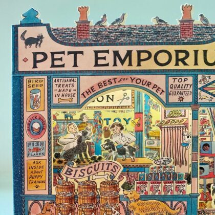 A 3D stand up card of a pet shop illustrated by Emily Sutton against a pale fabric background