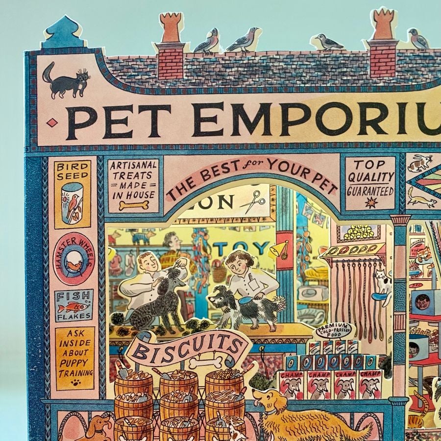 A 3D stand up card of a pet shop illustrated by Emily Sutton against a pale fabric background