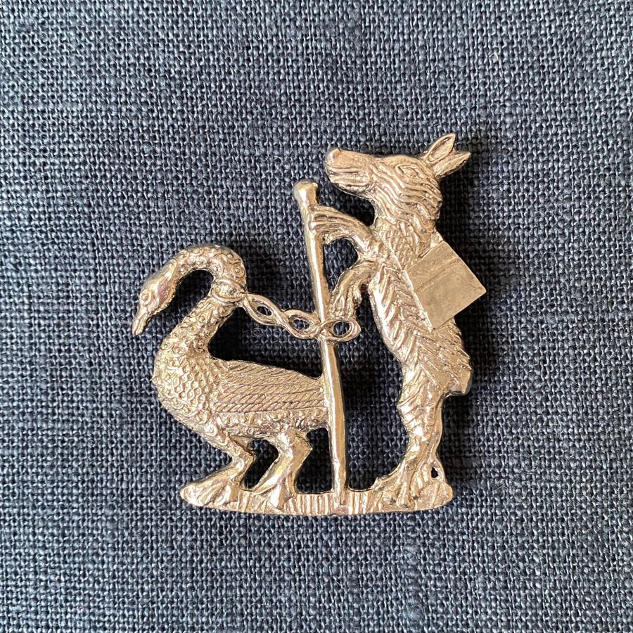 Pewter badge of an upright fox walking a goose